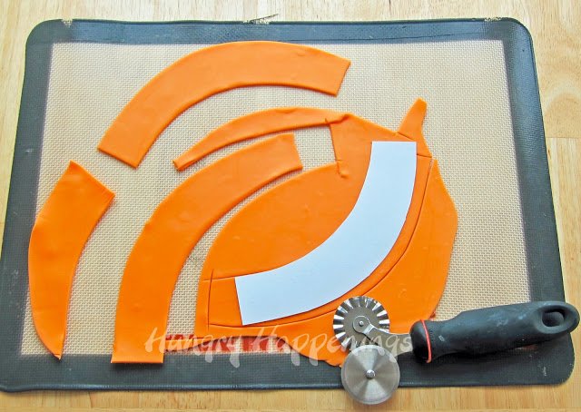 orange modeling chocolate cut into cupcake wrappers using a template and a pizza wheel. 