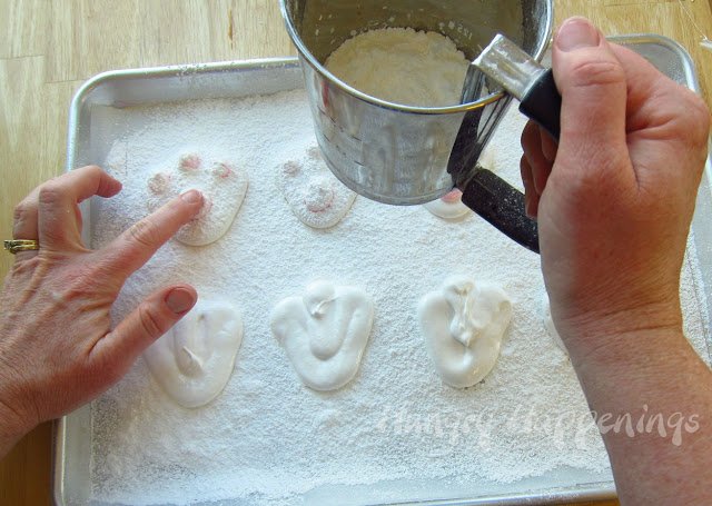 sifting powdered sugar over the marshmallow bunny feet and pressing down on the tips of the pink marshmallow dots.