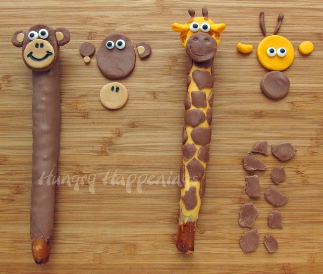 decorating a pretzel monkey using dark and light brown modeling chocolate and candy eyes and decorating a giraffe pretzel with yellow-orange and brown modeling chocolate and candy eyes. 