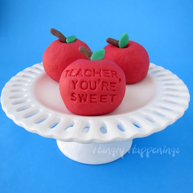 teacher appreciation apples made from white chocolate fudge set on a small white cake stand.