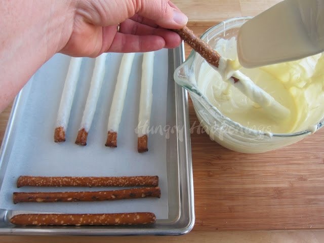 dipping pretzel rods in melted white chocolate. 