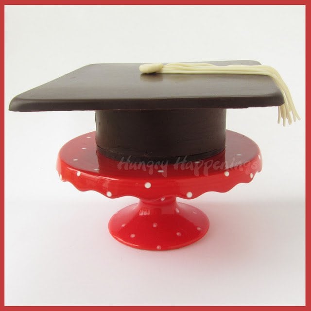 chocolate grad cap box on a red cake stand. 