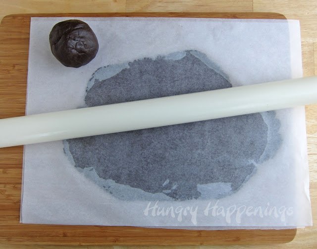 roll out chocolate cookie dough between two pieces of parchment paper