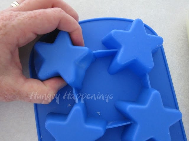reshaping fudge stars by pressing on the backside of silicone star mold. 