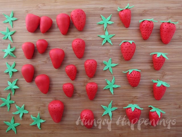 making strawberries out of strawberries and cream fudge topped with green fudge leaves. 