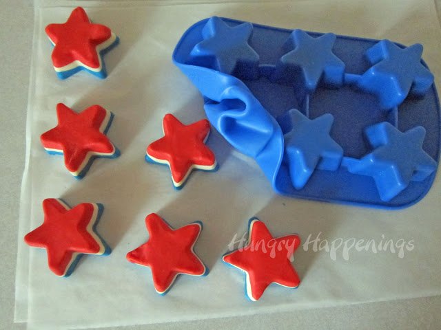 unmolding star-shaped red, white, and blue fudge from a silicone star mold. 