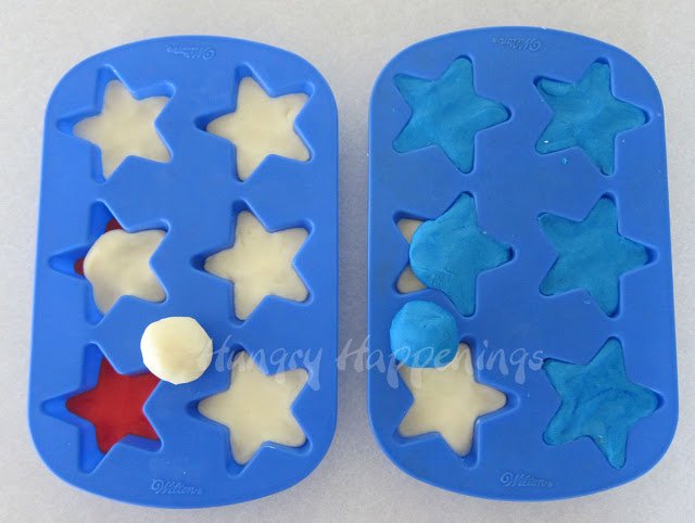 layering red, white, and blue fudge into silicone star molds. 