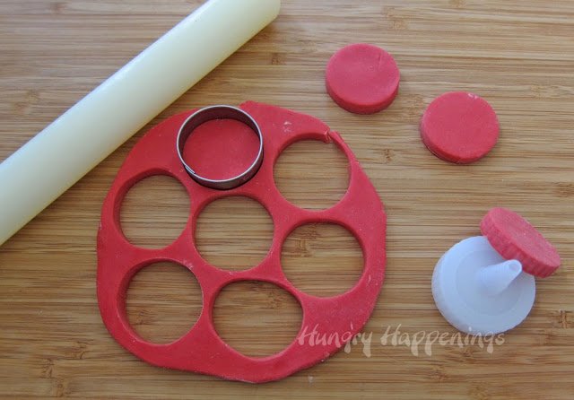 Cutting circles out of red modeling chocolate.