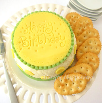 Cheese ball birthday cake decorated with "Happy Birthday" imprinted cheese and served with crackers.