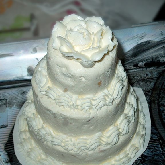 wedding cake cheese ball decorated with a white rose.