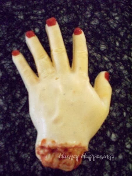 cheese ball hand with red pepper fingernails.