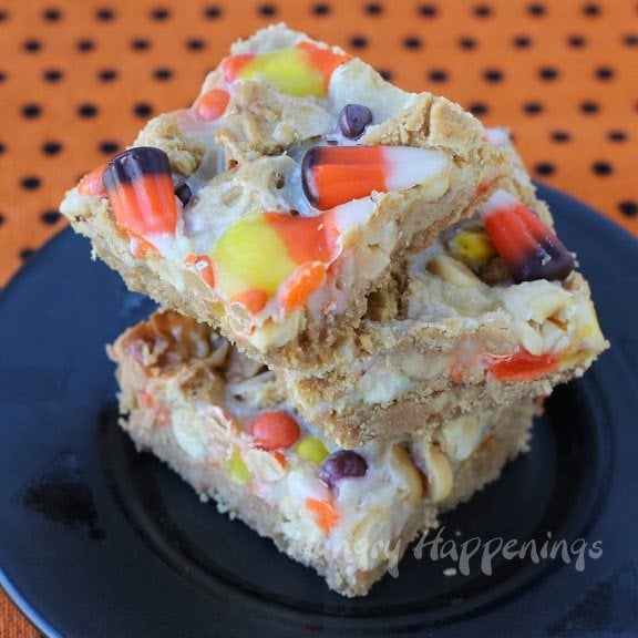 Halloween magic bars with a Nutter Butter Cookie crust, candy corn, Reese's Pieces, and peanuts. 