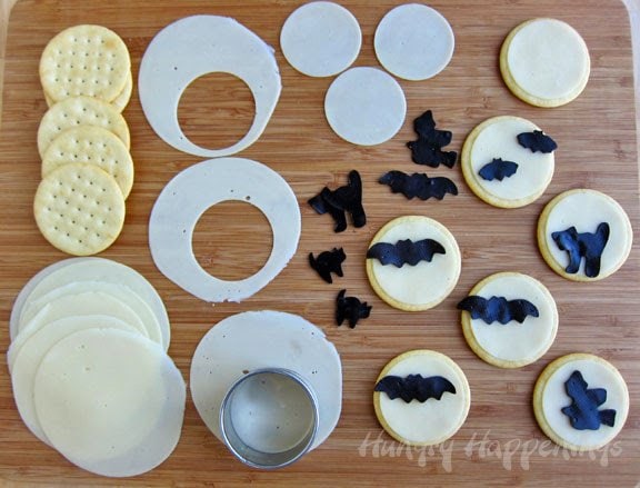 cutting out round slices of cheese a little smaller than a round cracker and adding black cheese bats, cats, and witches.