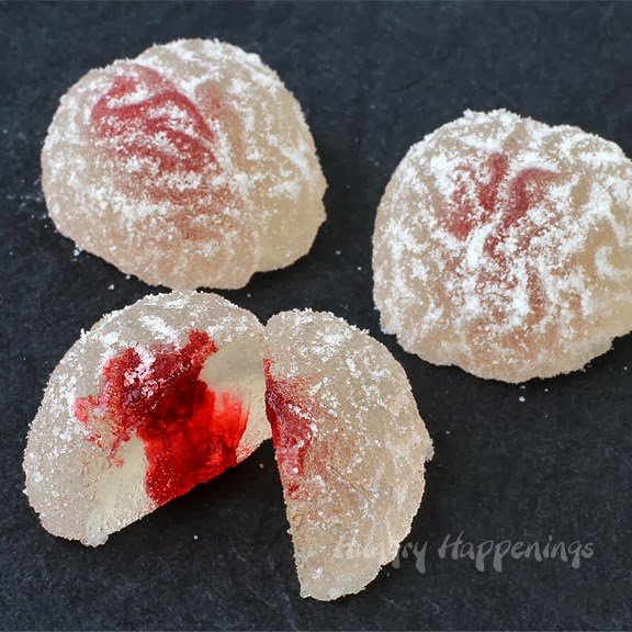 Cut open gumdrop brain showing a cross-section of red food coloring blood inside. 