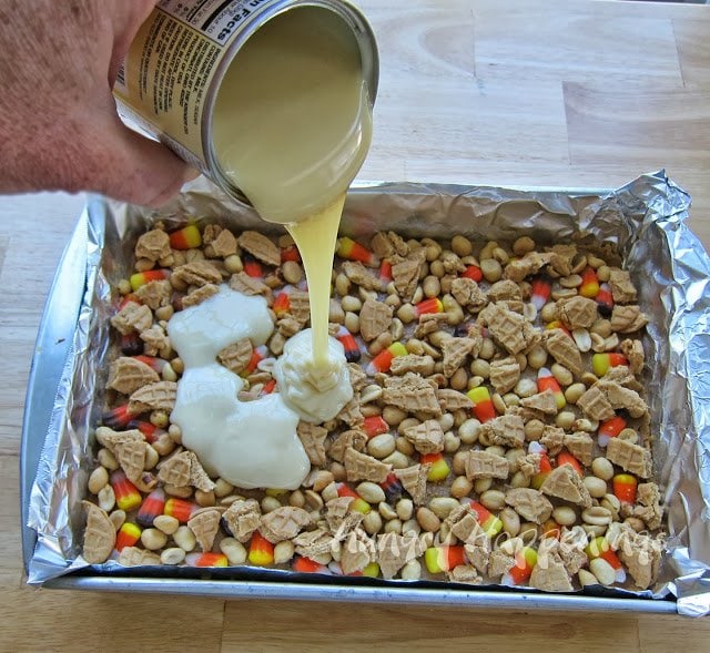 pouring sweetened condensed milk over layers of Nutter Butter Cookies, peanuts, and candy corn.