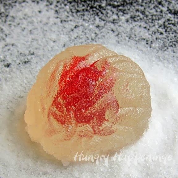 Translucent gumdrop brain on a pile of granulated sugar. 
