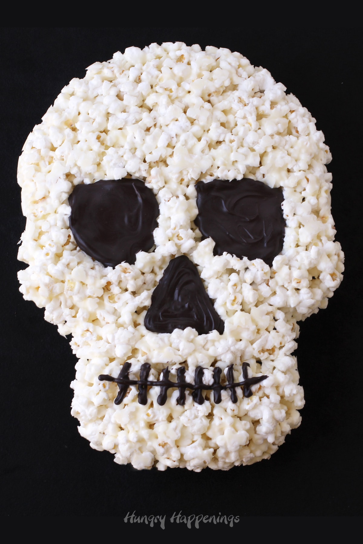 white chocolate popcorn skull on a black background. 
