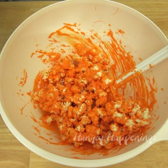 making orange-colored white chocolate popcorn. 