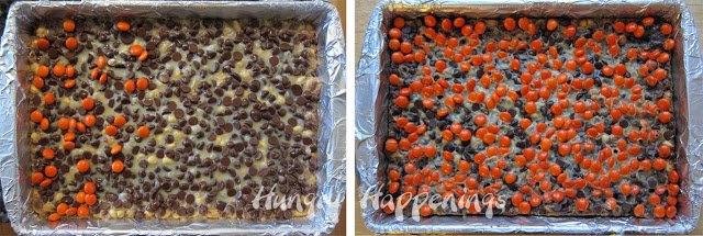 Orange Reese's Pieces layered on top of chocolate chips, sweet and condensed milk, peanuts, and a layer of chocolate cookie cake in a 9 by 13 pan.
