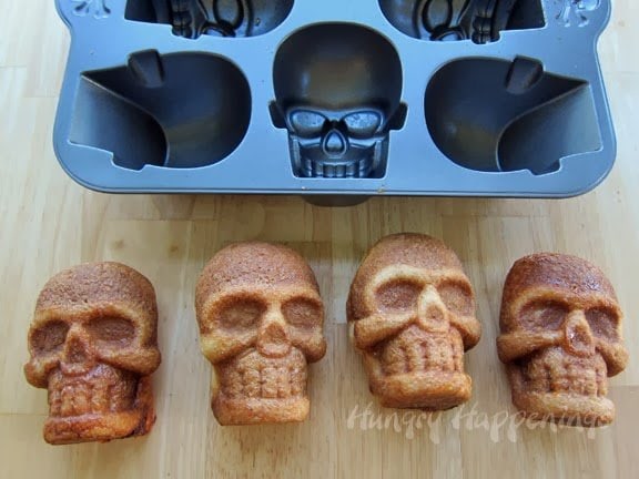 baked pizza skulls on the table in front of a skull pan.