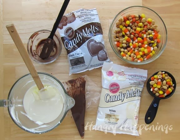 white chocolate candy corn bark ingredients including white and milk chocolate candy melts, peanuts, Reese's pieces, and candy corn.