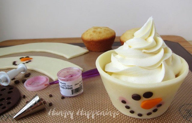 making snowman cupcakes wrapped in decorated white modeling chocolate