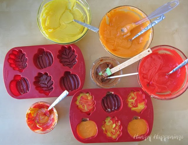 swirling red, yellow, and orange cake batter in silicone leaf molds and painting stems and adding orange cake batter to pumpkin molds. 