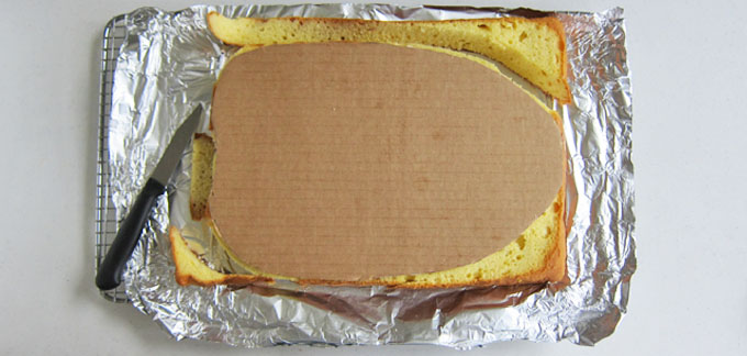 carving a cake using a cardboard template