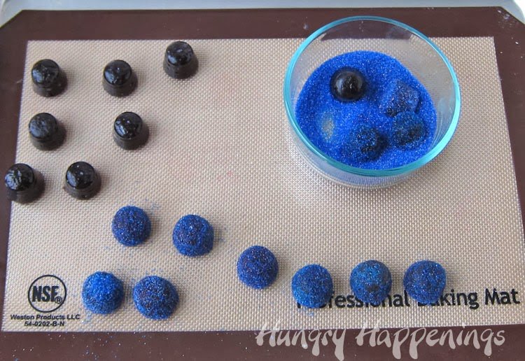 coating blueberry gumdrops in blue sugar.