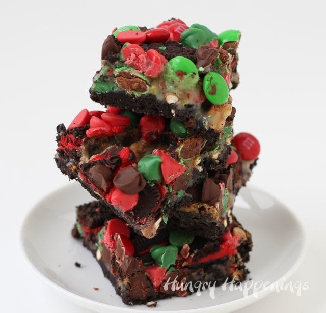 red and green M&M's and OREO magic bars stacked on a small round white dish. 