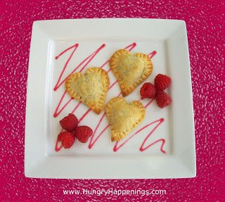 heart-shaped chocolate-filled pastries served with raspberry sauce and raspberries