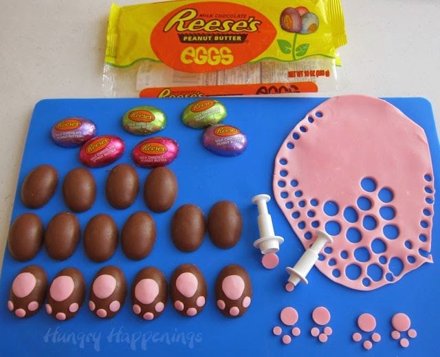 making Reese's Peanut Butter Eggs into bunny feet using pink modeling chocolate cut into circles using round plunger cutters. 