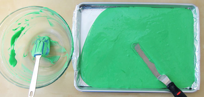 spreading green cake batter into a jelly roll pan