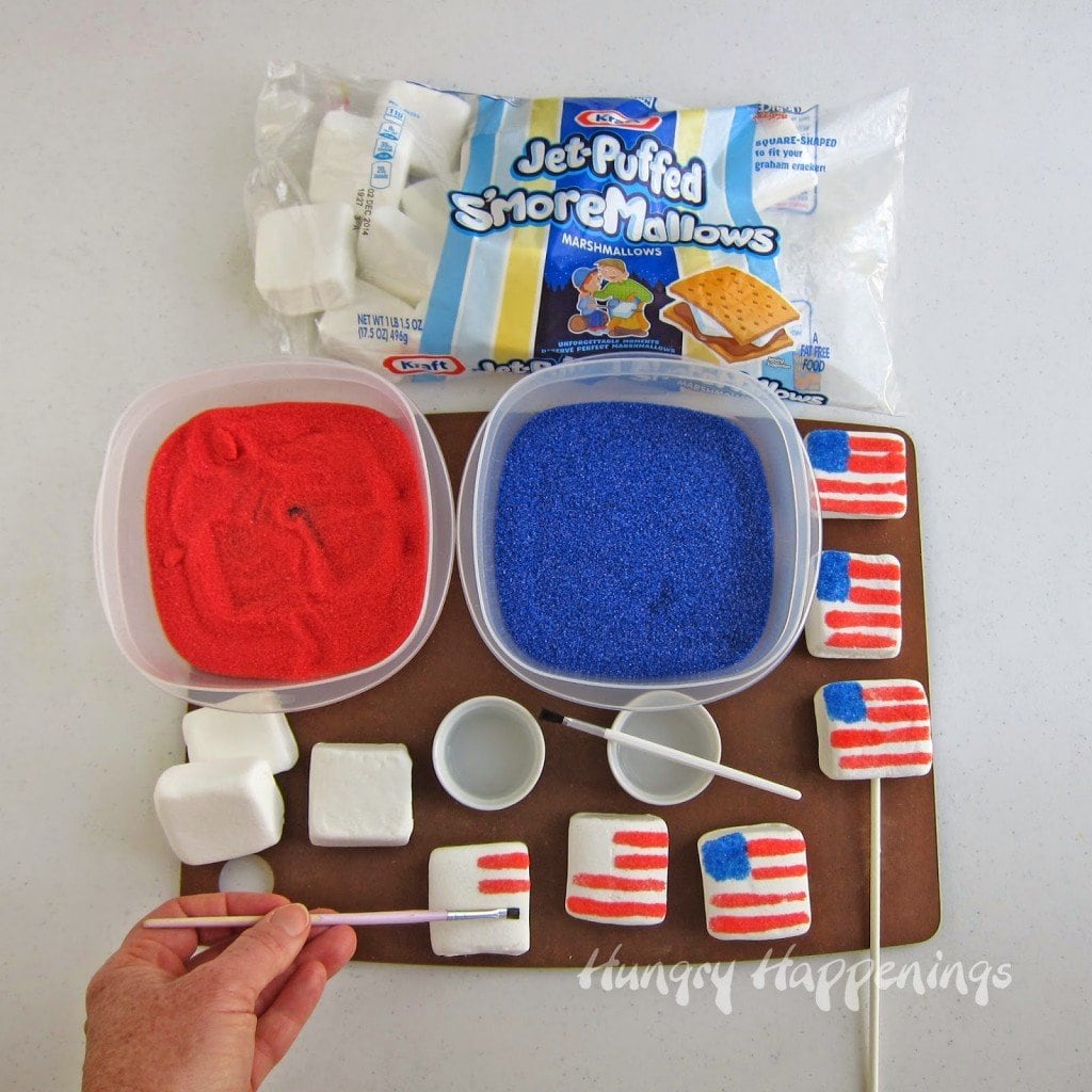 decorating marshmallow flags using Jet-Puffed  S'more Mallows, a paint brush, water, blue, and red sugar. 