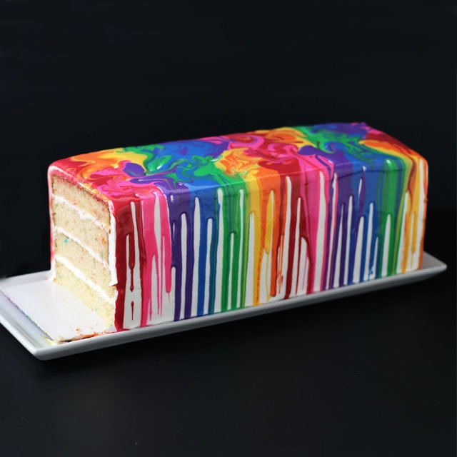Create the effect of melting crayons on the side of a cake using colorful white chocolate ganache. This Melting Rainbow Cake blends all the colors of the rainbow in a sweet dessert. 