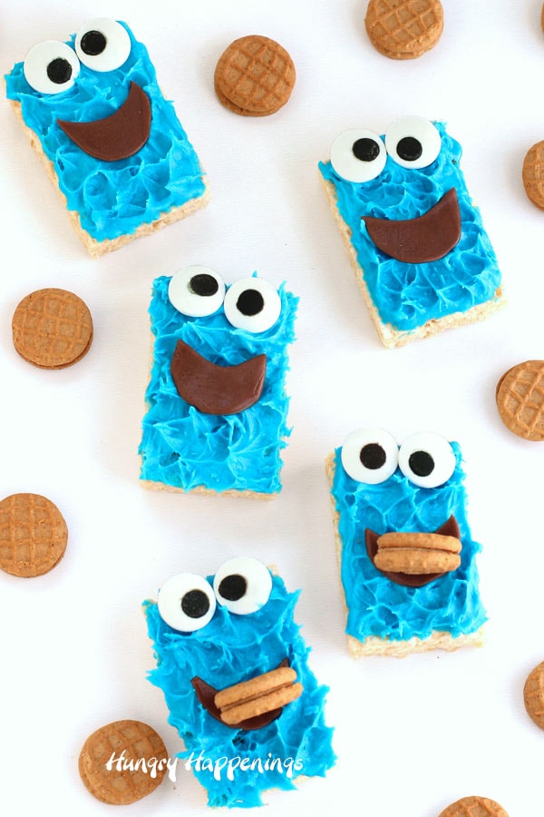 Rice Krispie Treat Cookie Monsters are decorated with blue frosting, candy eyes, Tootsie Rolls, and mini cookies.