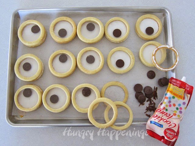 adding chocolate pupils to the googly eyed cookies.