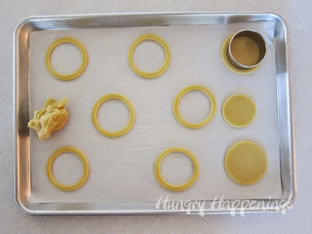 cutting the center out of round cookies.