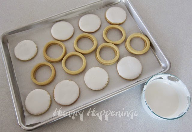 icing round cookies with white vanilla icing. 