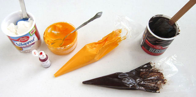 orange and black frosting in pastry bags