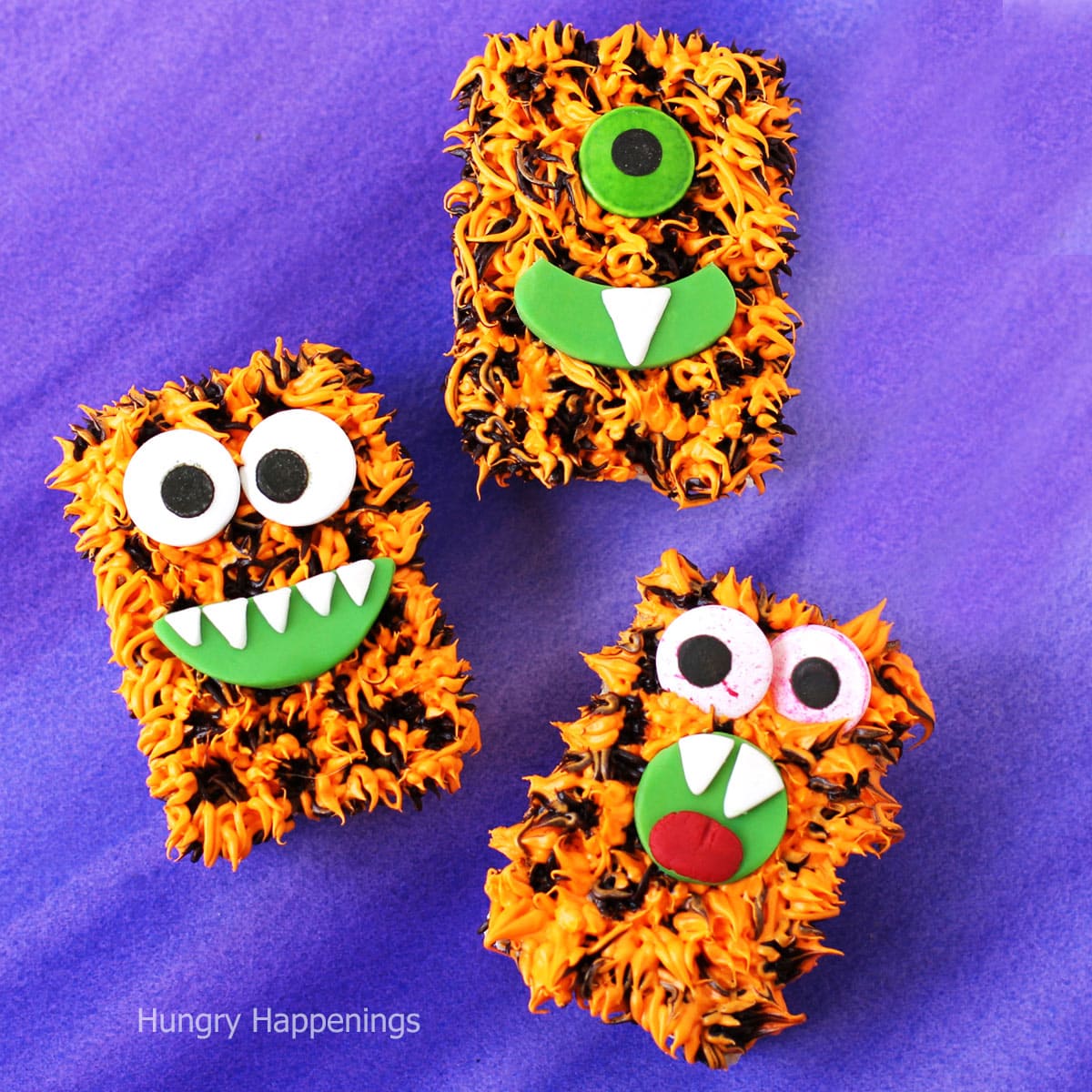 Rice Krispie Treat Monsters decorated with orange and black frosting fur. 