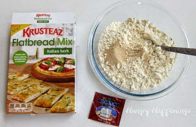 Kursteaz Flatbread Mix Italian Herb in a box and in a mixing bowl with the yeast on top. 