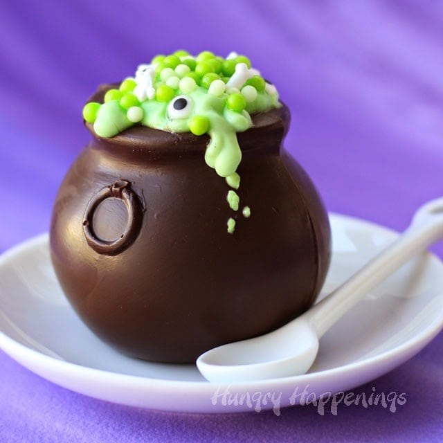 Chocolate Witch's Cauldron filled with green pudding and witch's brew candies and sprinkles. 