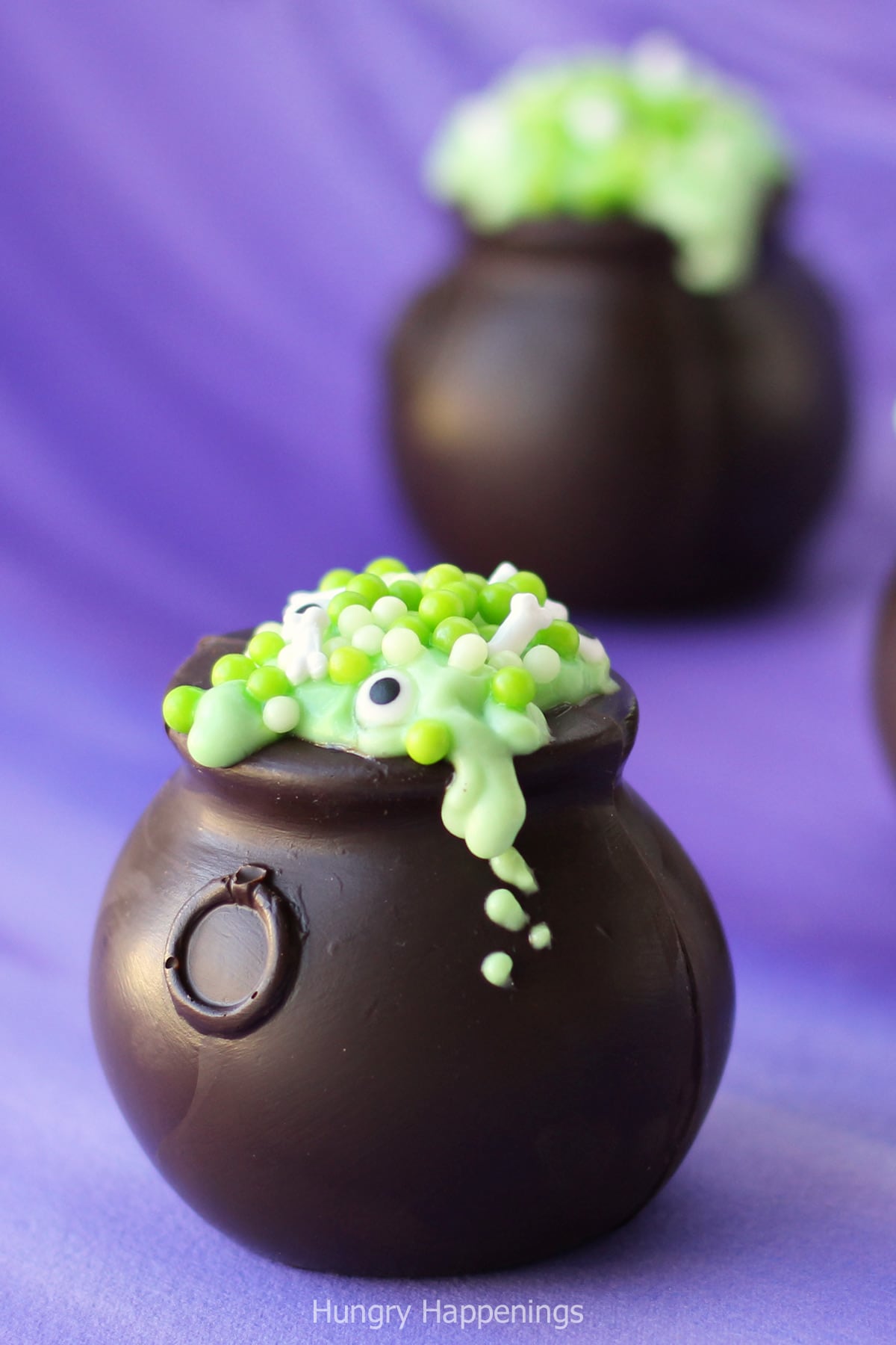 chocolate cauldrons filled with green pudding, green sugar pearls, candy bones and eyes. 