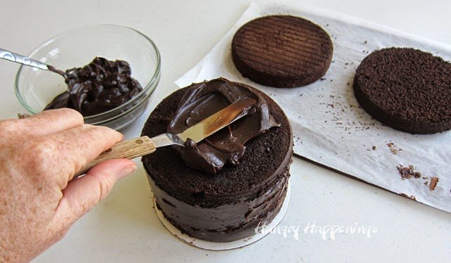 Covering a cake in chocolate ganache frosting.