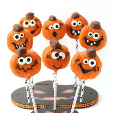 pumpkin rice krispie treat lollipops decorated with silly Jack-O-Lantern faces.