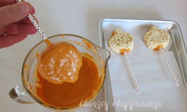 dipping pumpkin-shaped rice crispy treats into orange candy melts. 