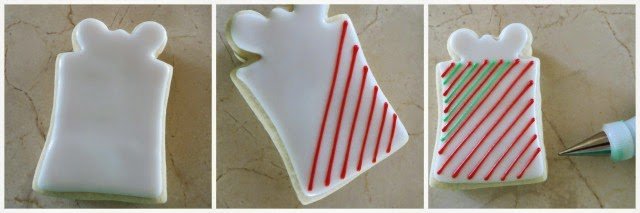 piping red and green stripes onto white iced Christmas present cookies. 