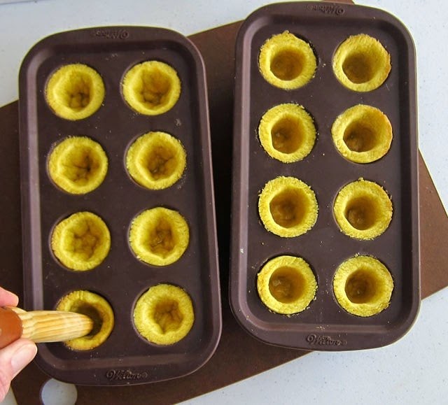 yellow cookies baked in a brownie pops mold have wells inside that can be made smooth using a wooden spoon hande. 