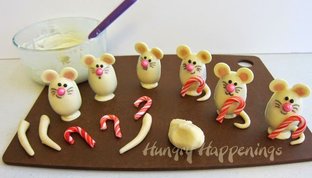attaching candy canes and white modeling chocolate tails to the mouse chocolates.